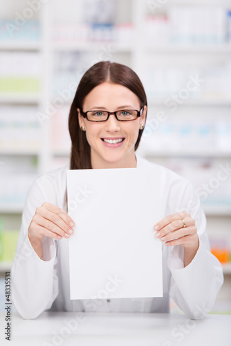 Photo: frau in der apotheke zeigt schild frau in der apotheke zeigt schild