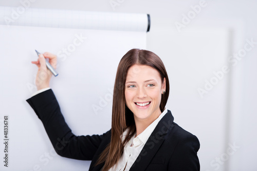 Photo: junge geschäftsfrau schreibt an das flipchart junge geschäftsfrau schreibt an das flipchart