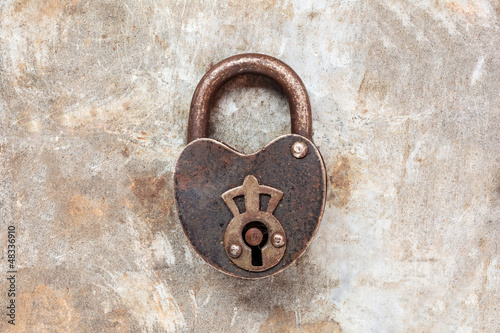 Photo: Vintage padlock on an iron grunge background Vintage padlock on an iron grunge background