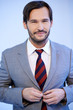 Photo: Smiling businessman buttoning his jacket Smiling businessman buttoning his jacket