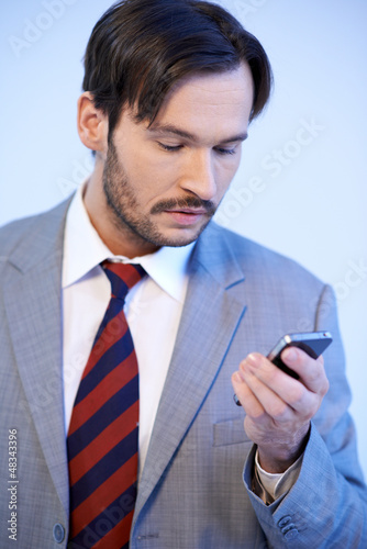 Photo: Man reading a text message on his mobile Man reading a text message on his mobile
