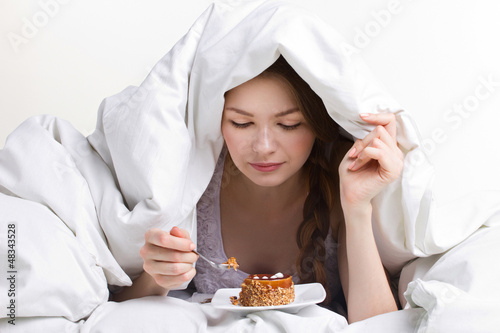 Photo: girl eating cake under cover girl eating cake under cover