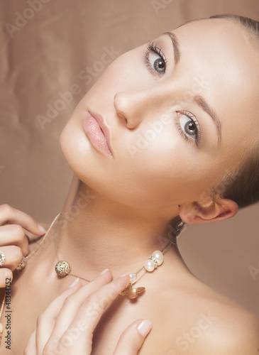 Photo: Beauty Woman Face. Elegant Golden Necklace with Pearls Beauty Woman Face. Elegant Golden Necklace with Pearls