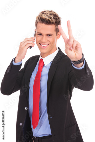 Photo: business man making victory on phone business man making victory on phone