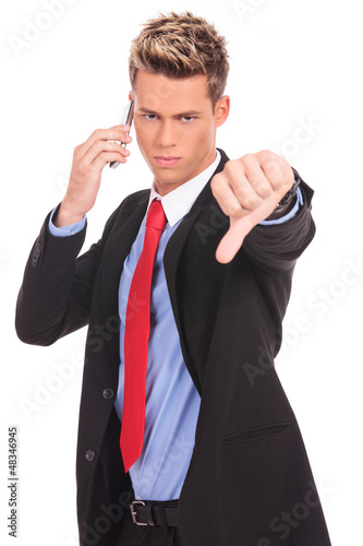 Photo: Business man with bad news on his cell phone Business man with bad news on his cell phone