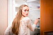 young woman looking for food in refrigerator