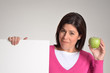 Mujer obesa en dieta sujetando un panel blanco y una manzana.