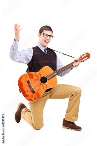 Photo: A happy male playing a guitar and singing A happy male playing a guitar and singing