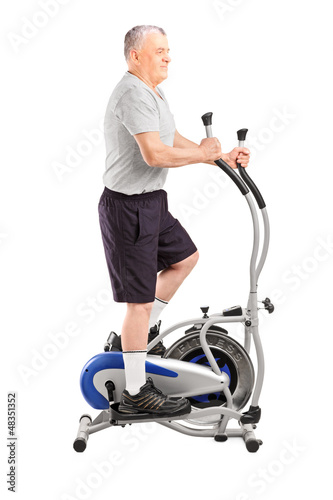Photo: Full length portrait of a mature sporty man exercising on a cro Full length portrait of a mature sporty man exercising on a cro