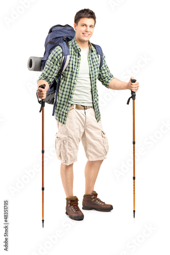 Photo: Full length portrait of a smiling hiker with backpack and hiking Full length portrait of a smiling hiker with backpack and hiking