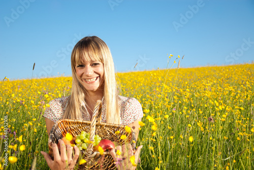 Photo: junge Frau mit Obstkorb in der Blumenwiese junge Frau mit Obstkorb in der Blumenwiese