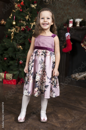 Photo: waiting for Santa Claus. Happy little girl near Christmas tree waiting for Santa Claus. Happy little girl near Christmas tree