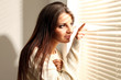 Photo: Beautiful young woman near window Beautiful young woman near window