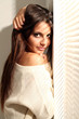 Beautiful young woman near window