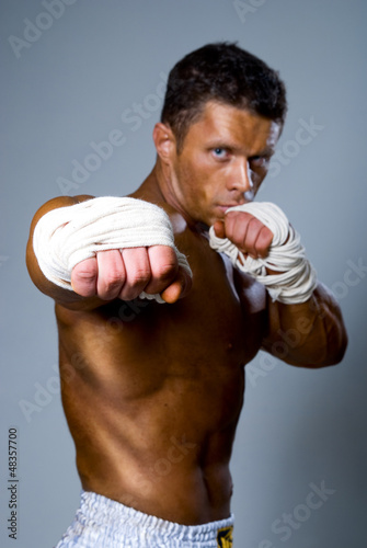 Photo: fighter punching. A fist in the foreground fighter punching. A fist in the foreground