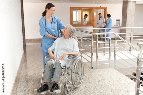 Photo: Nurse watching over old women sitting in wheelchair Nurse watching over old women sitting in wheelchair
