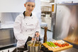 Smiling chef stirring soup