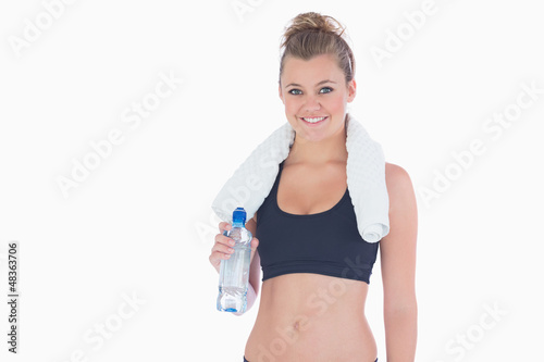 Photo: Woman smiling while holding a bottle of water Woman smiling while holding a bottle of water