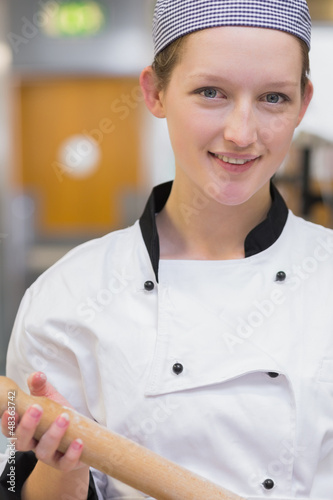 Photo: Woman holding rolling pin while smiling Woman holding rolling pin while smiling