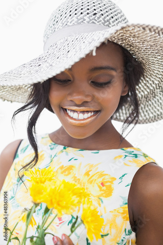 Photo: Woman standing looking at yellow flowers Woman standing looking at yellow flowers