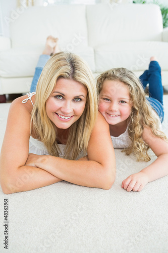 Photo: Mother and daughter resting on the carpet Mother and daughter resting on the carpet
