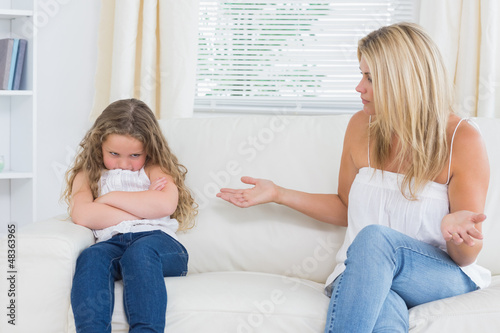 Photo: Angry mother sitting with her daughter on the sofa Angry mother sitting with her daughter on the sofa