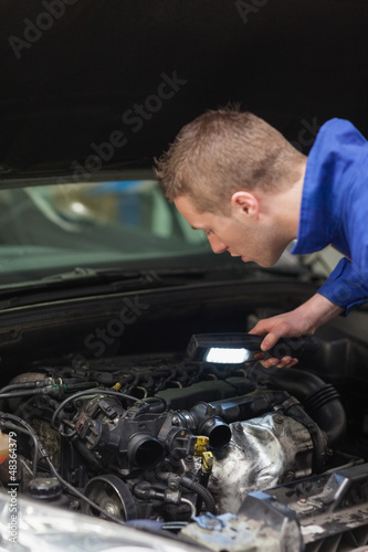 Photo: Repairman examining car engine Repairman examining car engine