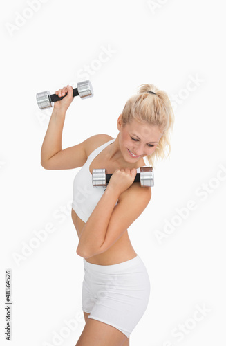Photo: Young woman exercising with dumbbells Young woman exercising with dumbbells