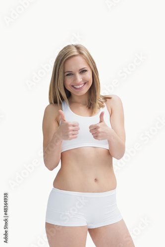 Photo: Portrait of happy woman in sportswear gesturing double thumbs up Portrait of happy woman in sportswear gesturing double thumbs up