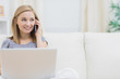 Photo: Casual woman using laptop and cellphone at home Casual woman using laptop and cellphone at home