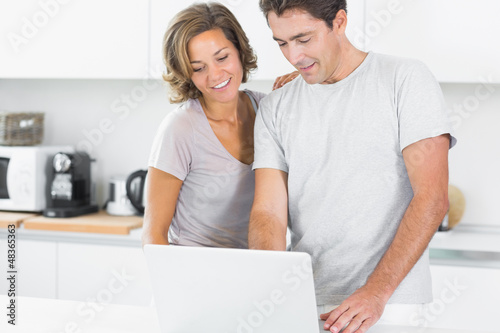Photo: Couple using laptop together Couple using laptop together
