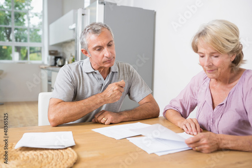 Photo: Couple reading documents together Couple reading documents together