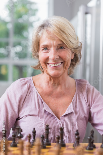 Photo: Smiling woman playing chess Smiling woman playing chess