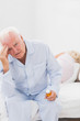 Elderly man suffering while woman sleeping on the bed