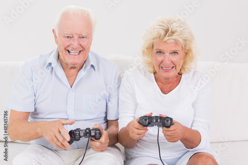 Photo: Aged couple playing video games Aged couple playing video games