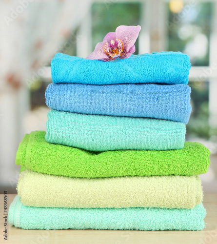 Photo: Stack of towels with fragrant flower on window background Stack of towels with fragrant flower on window background