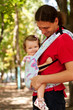 Happy baby sitting in a carrying sling.