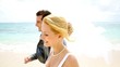 Bride and groom walking on a sandy beach