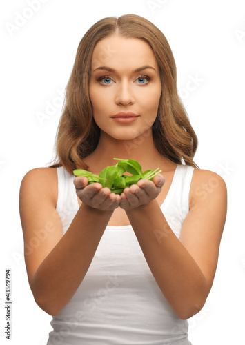 Photo: woman with spinach leaves on palms woman with spinach leaves on palms
