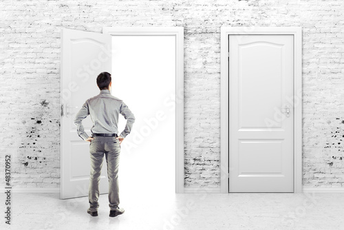 Photo: young business man in front of an open door young business man in front of an open door