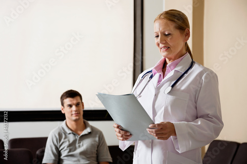 Photo: Female Doctor Looking At File Female Doctor Looking At File