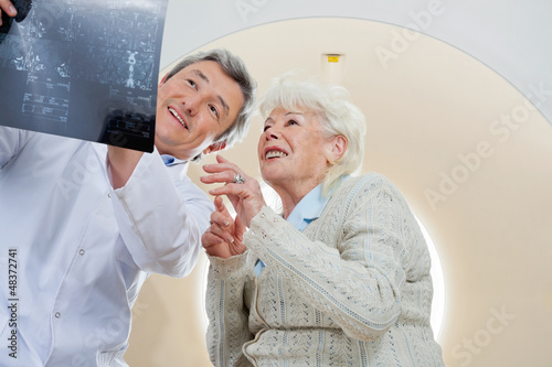 Photo: Doctor With Patient Looking At MRI X-ray Doctor With Patient Looking At MRI X-ray