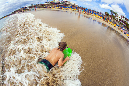 Photo: boy has fun at the beach boy has fun at the beach