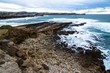 Beach of rocks with the town of Muengo in the background