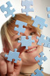 Junge Frau legt Puzzle-Teile zusammen