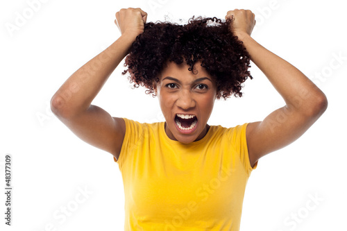 Photo: Angry young woman pulling her hair out Angry young woman pulling her hair out