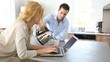 Woman using laptop computer while boyfriend serves tea