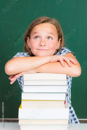 Photo: schülerin mit bücherstapel im klassenzimmer schülerin mit bücherstapel im klassenzimmer