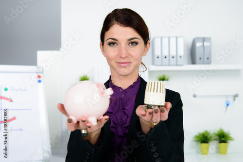 Photo: businessfrau mit sparschwein und thermostat businessfrau mit sparschwein und thermostat