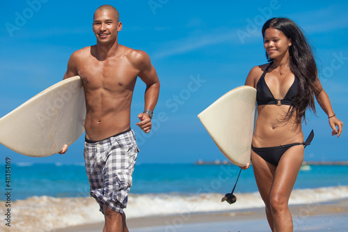 Photo: Young couple running on beach Young couple running on beach